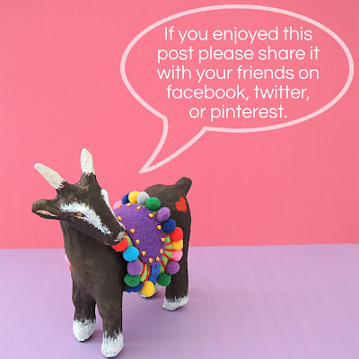 paper mache goat with pom pom saddle blanket asking for social media shares