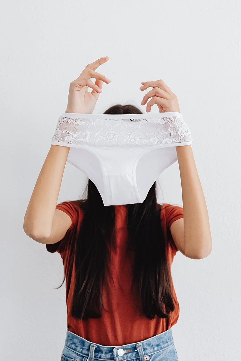 woman is holding white panties in her hands