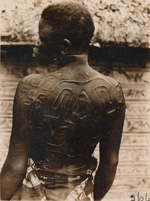 Congolese woman's back, showing scarification art with swastikas and other designs.