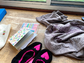 Notebook, gel pens, yoga clothing on a wooden floor 