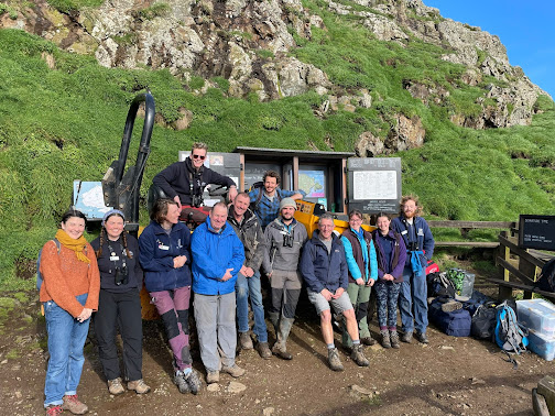 A group of volunteers and staff in front of our dumper truck.