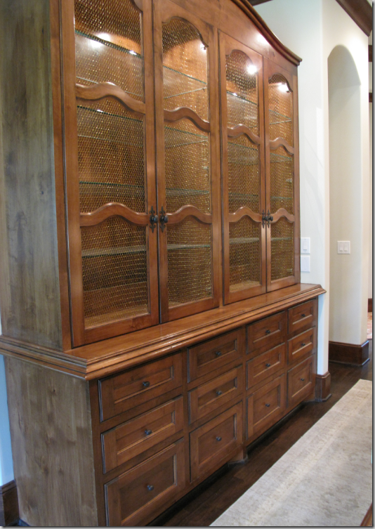 The built in china cabinet with wired doors and arched top.