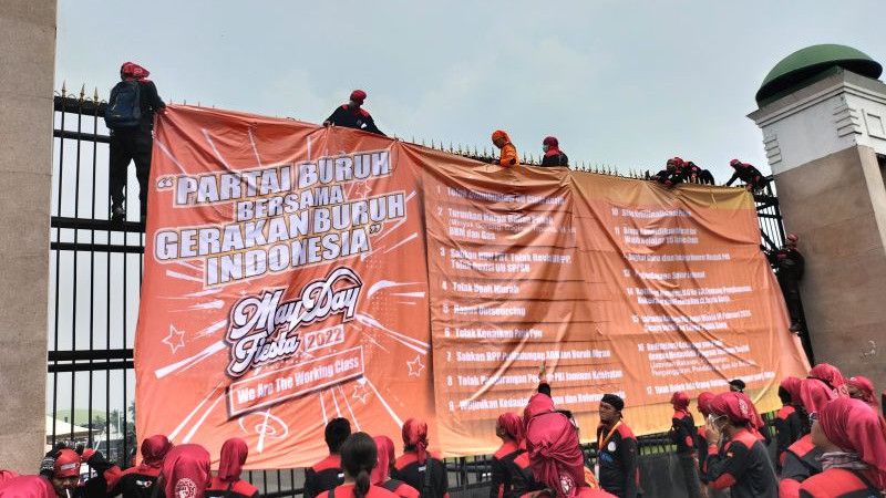 Massa Buruh Geruduk DPR, Bentangkan Spanduk Tuntutan di Pagar Gedung Parlemen