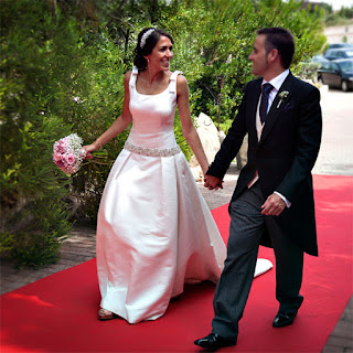 Los novios se miran enamorados caminando por la alfombra roja. Qué guapos están los dos!!