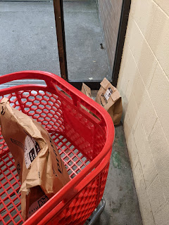 Red shopping cart with two bags in and two still on the floor
