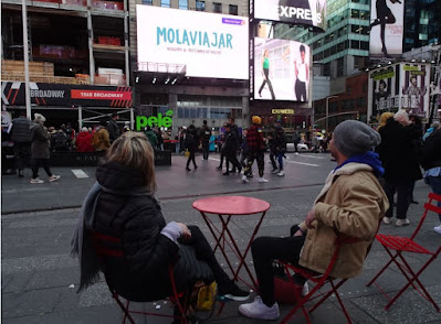 Adri y Gosi de Mola Viajar viendo su anuncio en Times Square.