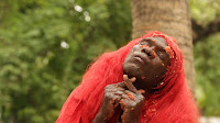 person in red wig performing a ceremony