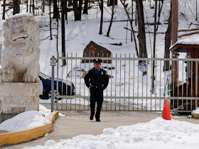 A security guard walks along the drive of the main gate entry to the Falun Gong Dragon Springs compound, Friday, March 8, 2019, Julie Jacobson / AP