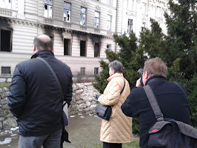 This man is taking a photo of a woman taking a photo. What a vulture!