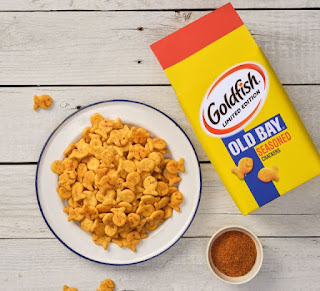 A pack of Old Bay Seasoned Goldfish crackers next to a plate of the same crackers.
