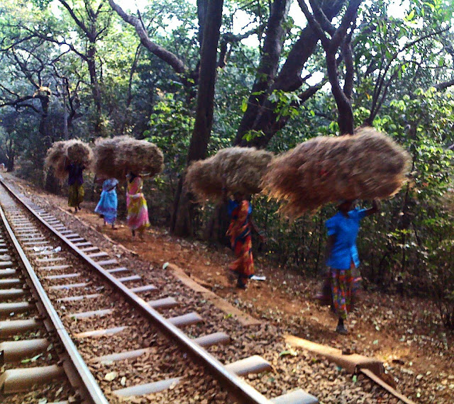 women carrying loads of hay