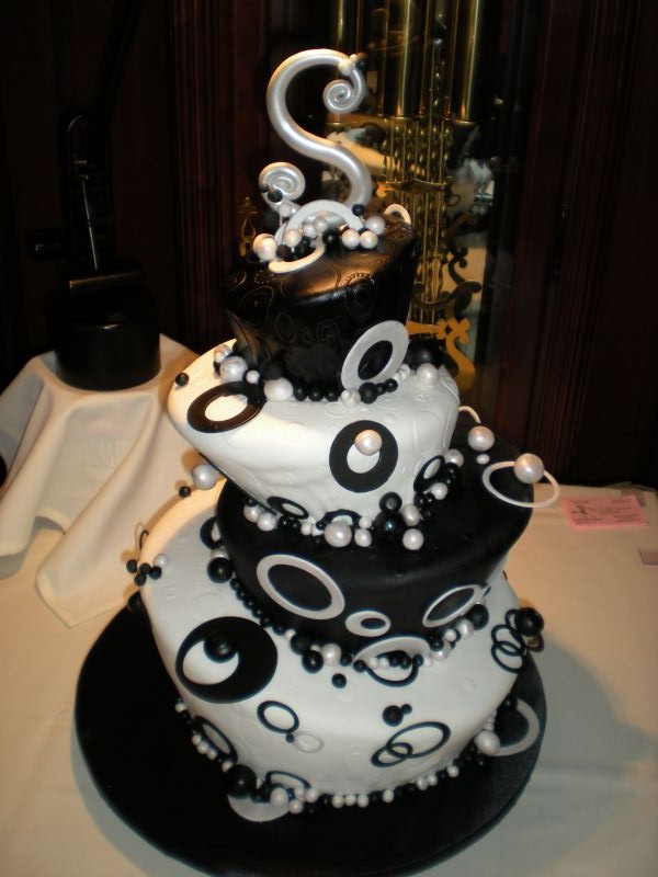 Five tier modern black and white wedding cake with gold swirls and round 