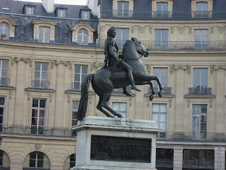 Louis XIV seated on a bucking horse at Place des Victoires. An earlier one showed him on a pedestal supported by four chained prisoners.