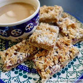 close up image of oatmeal coconut raspberry jam bar cookies on a plate