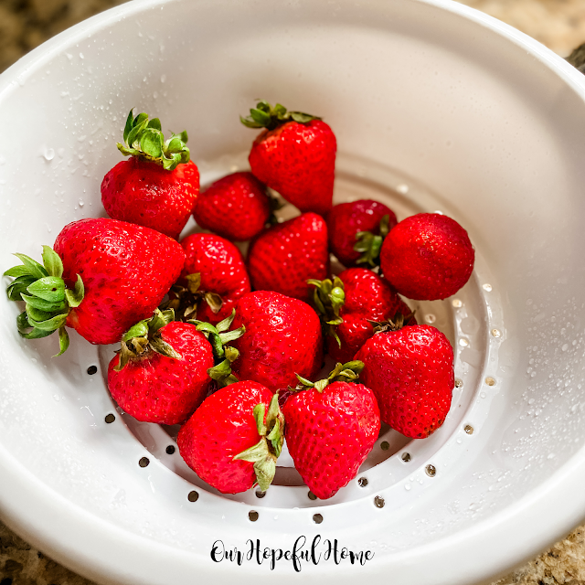 bright red strawberries white colander