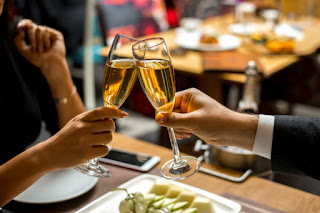 couple-are-holding-glasses-with-champagne-with-fruit-plate-side-view