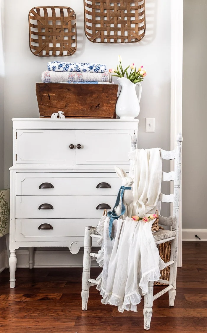 white dresser, tobacco baskets, rustic chair, white rabbit, pink tulips, ruffled throw