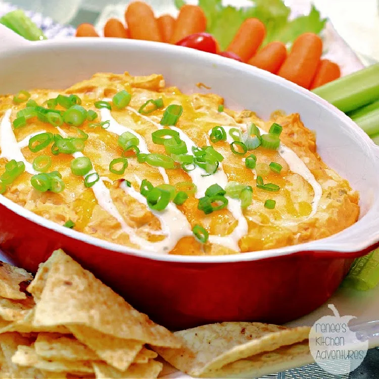 Creamy Ranch Buffalo Chicken Dip with tortilla chips and raw carrots and celery ready to eat