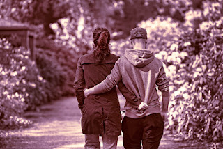 Sepia colored man and woman walking on a forest trail