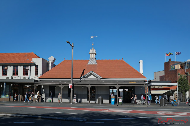 Newtown station in full sun with shops on the left, the 'Townie' on the right. Fujifilm X100VI in Newtown