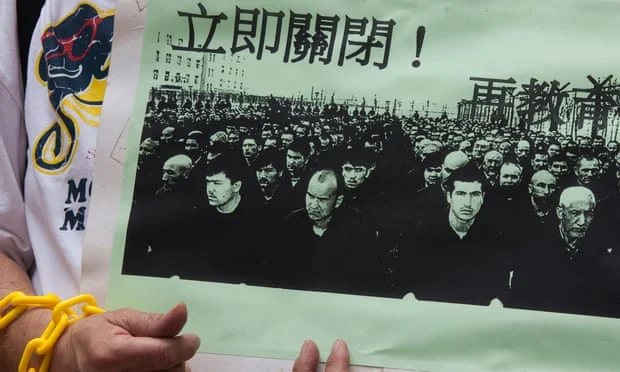 A protestor displays a photo of Uyghur prisoners in Xinjiang
