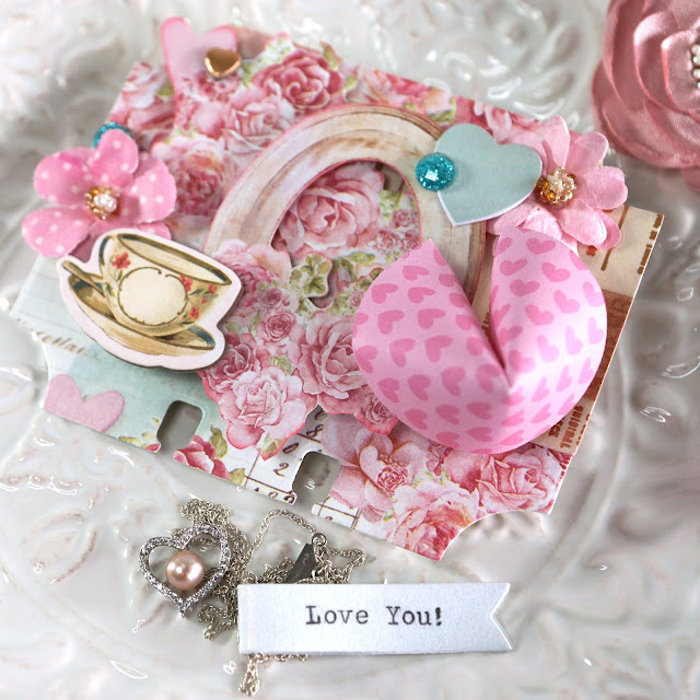 Heidi Swapp Memorydex Valentine's advent calendar made with the Prima With Love collection by Frank Garcia; 3D fortune cookie die cut decorated with fussy cut ephemera, chipboard stickers and paper flowers