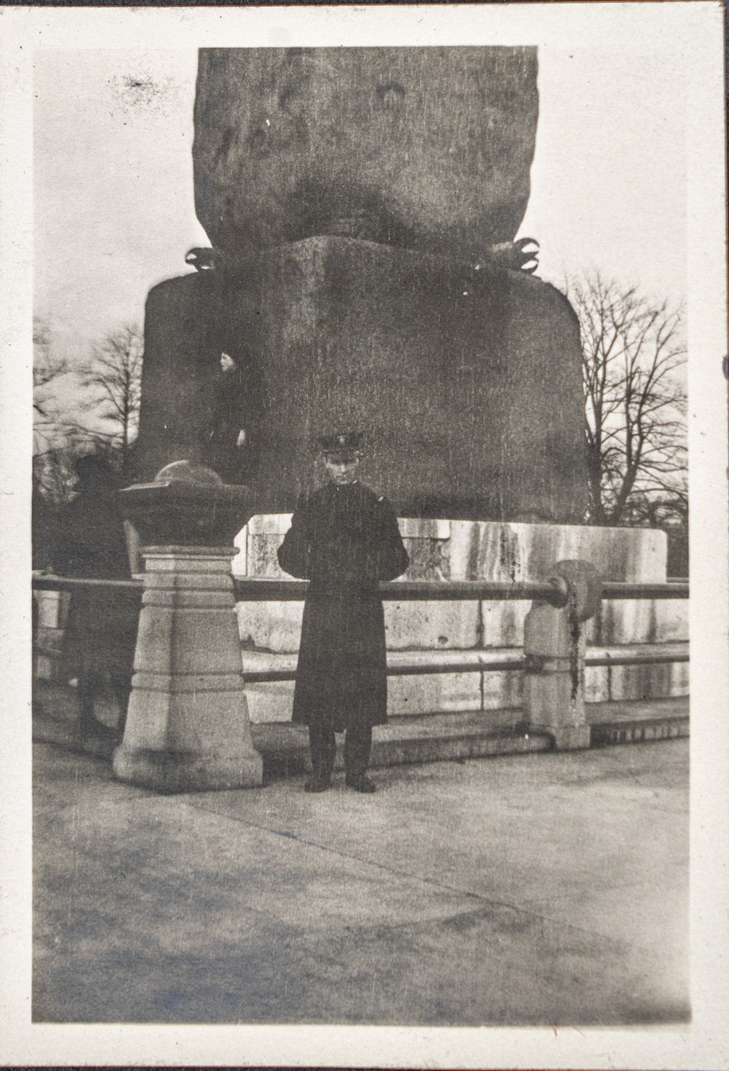 Frederick Le Roy Schaefer standing in front of the Obelisk in Central Park. He appears to be wearing a long military coat and hat.