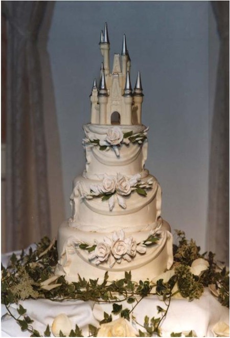 A true fairytale wedding cake in white and silver with a Cinderella's castle