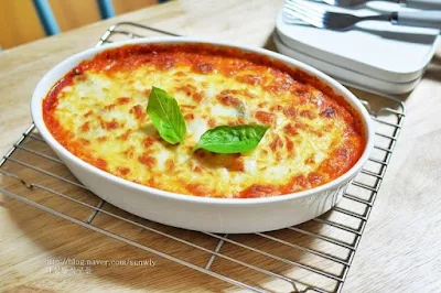 "Modern tteokbokki with cheese and noodles served in a stylish Korean cafe."
