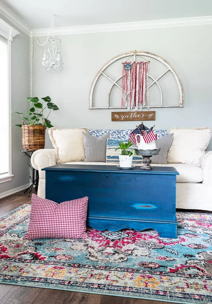 living room with patriotic Americana decor pillows, plants, antique window, scrap fabric flag
