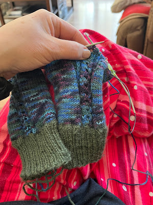 In progress picture of First Night Socks by Dana Rae Makes knit in a blue multi coloured Happy Feet yarn with contrast cuffs knit in green Sisu yarn