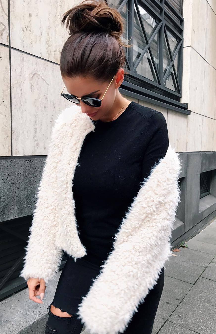 cozy fall outfit idea / black top + white fur jacket + ripped jeans
