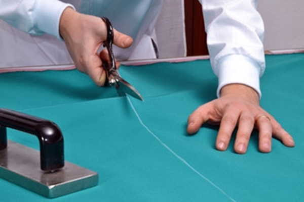 Sastre cortando tela con tijeras