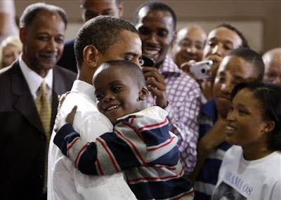 Obama and a little boy sharing a great big hug . 