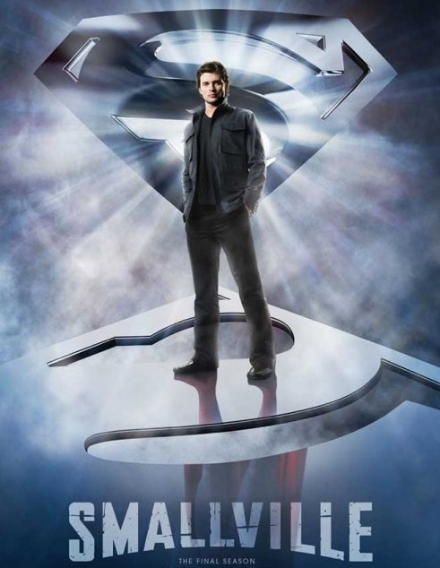 Tom Welling as Clark Kent dressed in black standing atop an mirror-like Superman emblem which reflects him up to his waist in the familiar blue suit, red boots, and cape