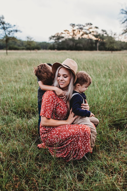 Mother in a field holding her two sons