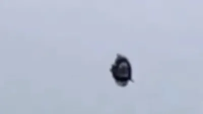 Paraglider chases UFO that nearly hits his craft.