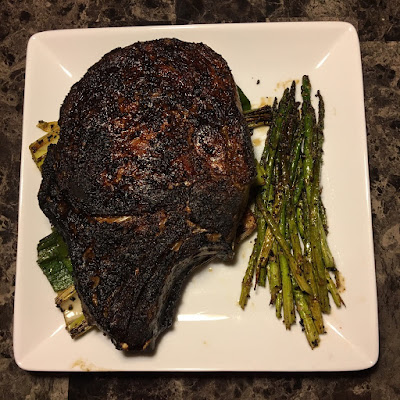 Bone-in ribeye grilled Pittsburgh with leeks and asparagus