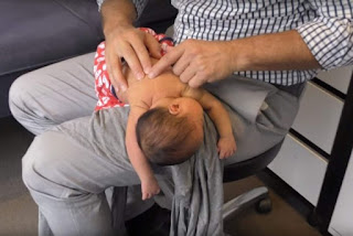 IMAGE: MELBOURNE CHIROPRACTOR IAN ROSSBOROUGH CRACKS THE BACK OF A FOUR-DAY-OLD BABY. (YOUTUBE)