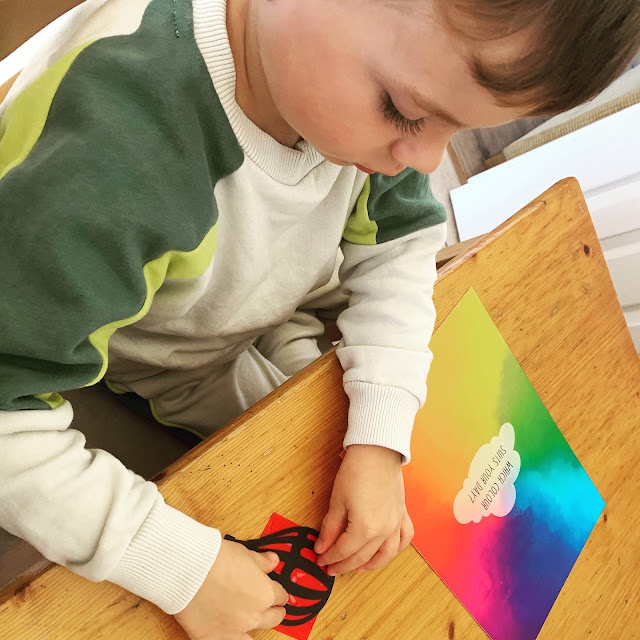 Boy making paper hot air balloon, with red tissue