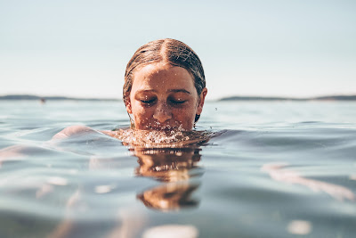 Image of a woman enjoying the benefits of blowing bubbles into the water