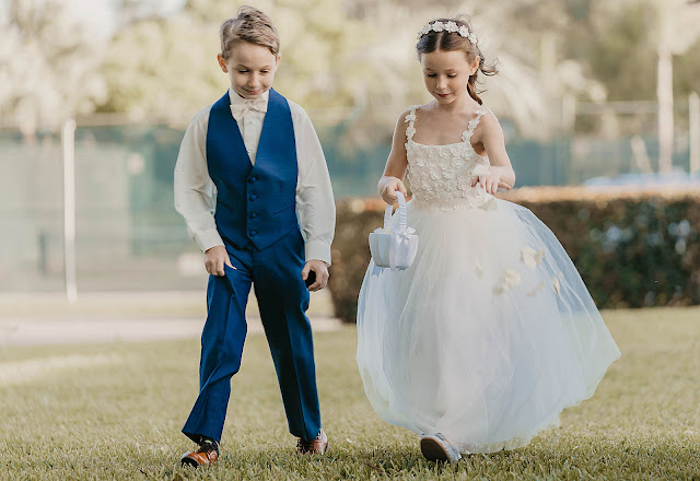 Ring bearer and flower girl walking together in Ceremony