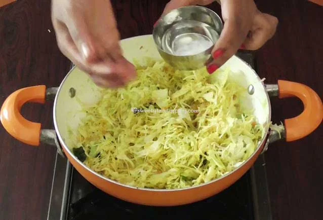 Cabbage and spices in the pan, covered and gently steaming to perfection, a crucial step in preparing Cabbage Poriyal.