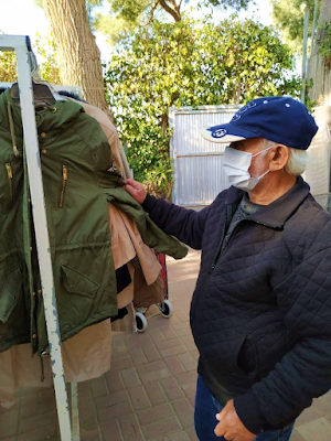 Man looking through coats at Israel Relief Aid Center partner