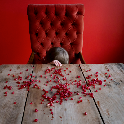 bambina su tavolo con petali rosa