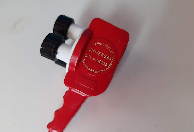 Anos 60 MIniatura de plástico, souvenir / lembrancinha de filmadora vermelha da Universal City Studios que pressionando o botão mostra 18  cenas / cenários de filmes do estúdio , fabricado na Alemanha, 1963 Tartaglia Imports  7,5cm de altura  ( o botão, às vezes, emperra)  R$ 20,00 