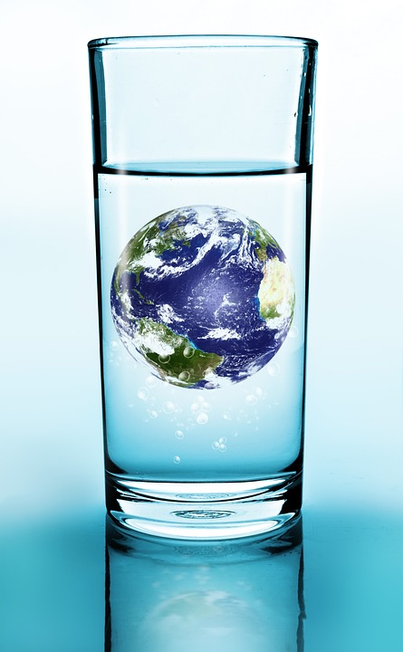 ID: a glass of water is pictured with the earth floating inside it and the Atlantic Ocean facing out..