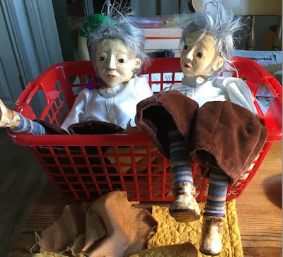 Two puppets by Corina Duyn lying in a basket waiting for their jackets to be sewn