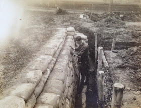 A photograph of a man standing in a training trench.