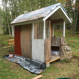 Lekstugans långsida börjar få rödfärg och verandan första omgången av vit linoljefärg